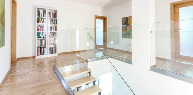 glass railing and bannister inside a home on the second story.