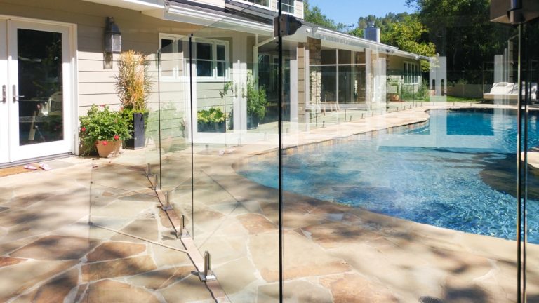clear glass pool fence showing the patio and pool behind the fence.