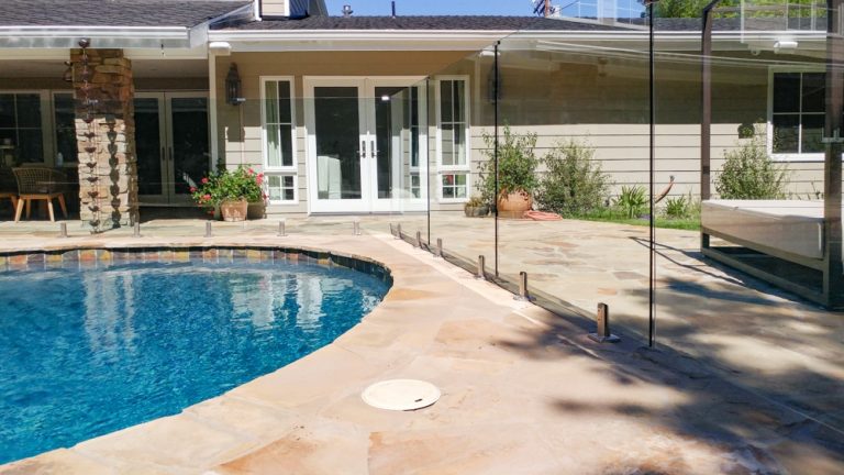 frameless glass pool fence in a residential back yard patio.