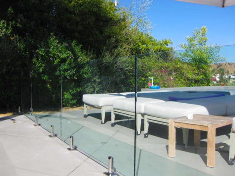 clear glass pool fence in front of tanning beds outside