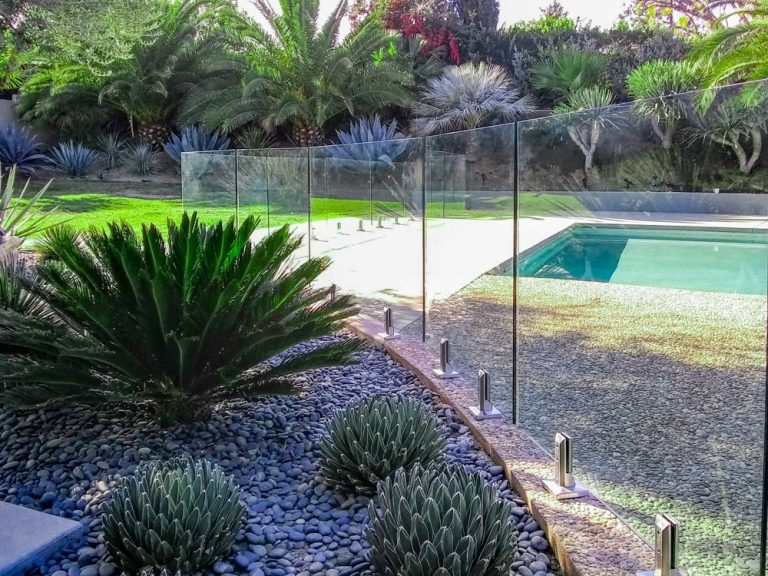 Glass pool fence surround a garden and swimming pool