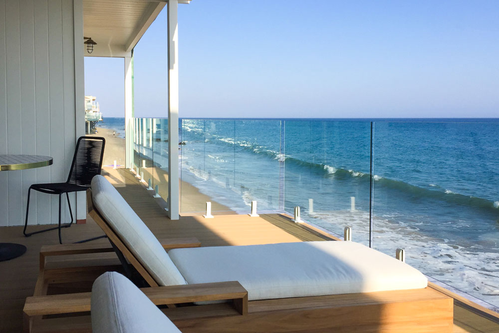 Glass railing on a wooden balcony overlooking the ocean