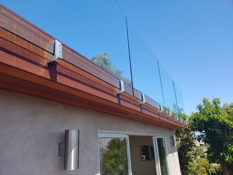 Glass railing mounted to the side of a rooftop balcony
