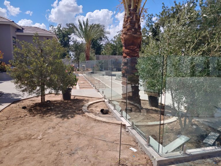 Long glass railing in a back yard mid-development