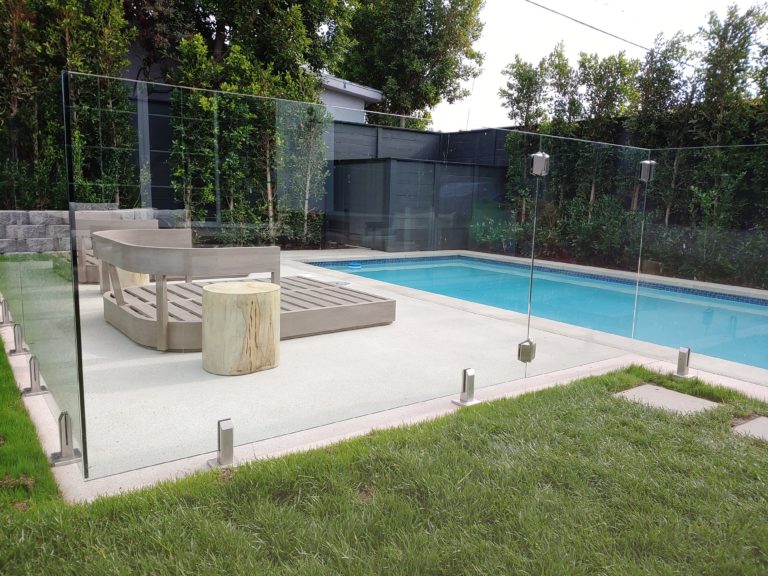 Glass pool fencing with a glass gate in a back yard