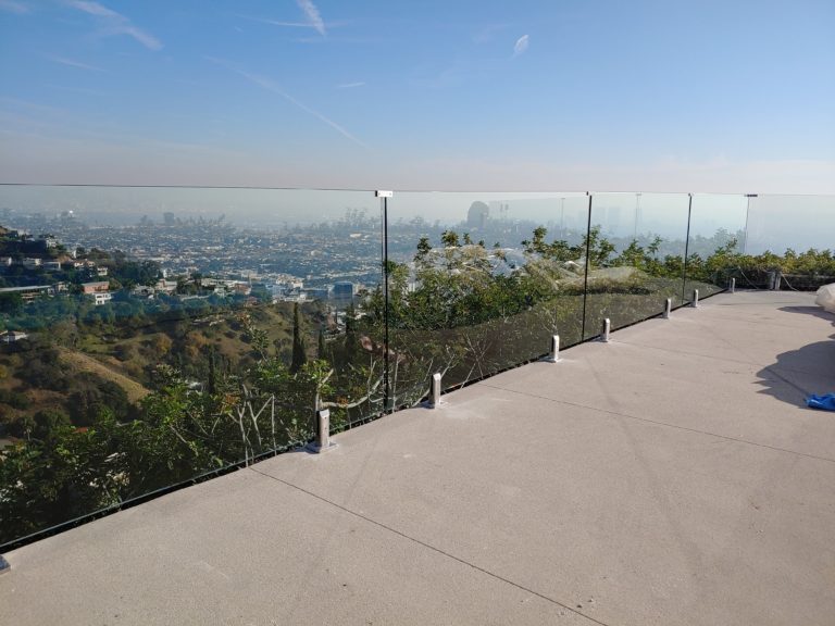 Frameless glass fencing on a large patio overlooking Los Angeles