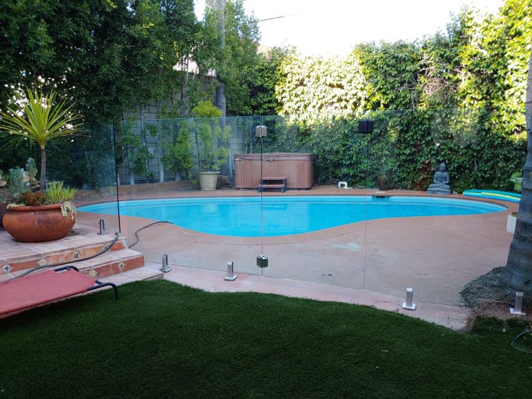 Glass pool fence with a frameless glass gate in a backyard