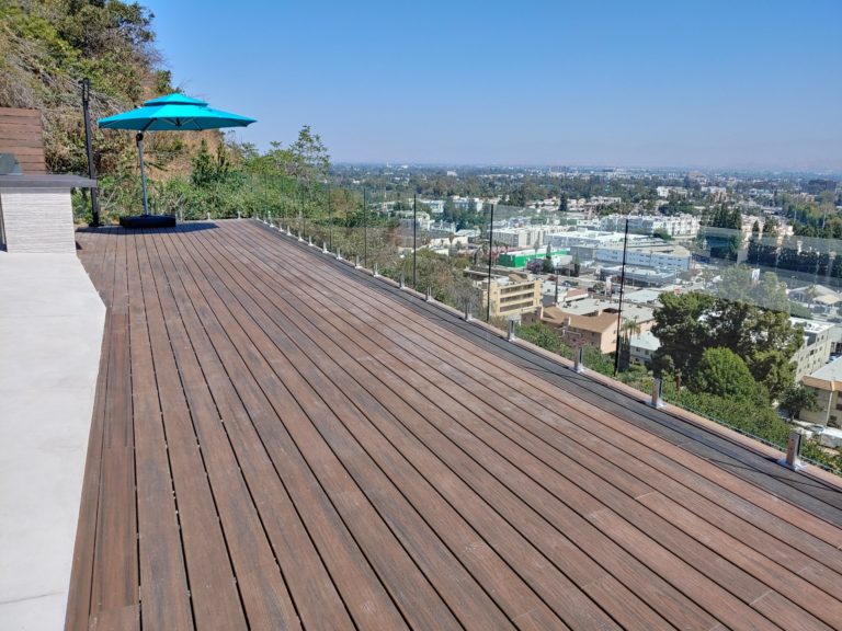 Frameless glass railing on a wooden deck overlooking Los Angeles