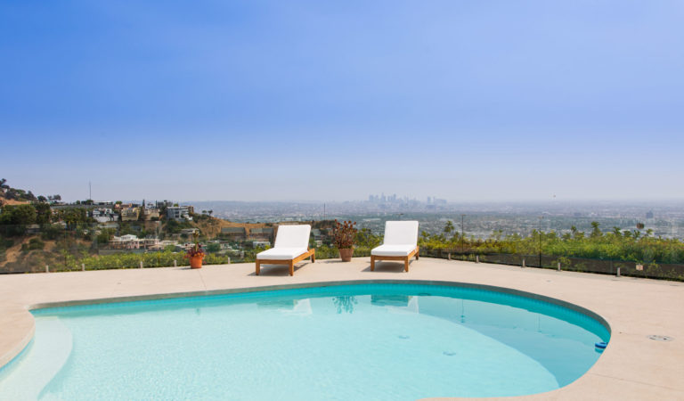Frameless glass pool fence on an outfoor balcony overlooking Los Angeles