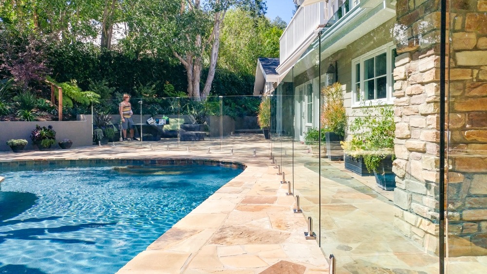 Glass pool fence surrounding a swimming pool